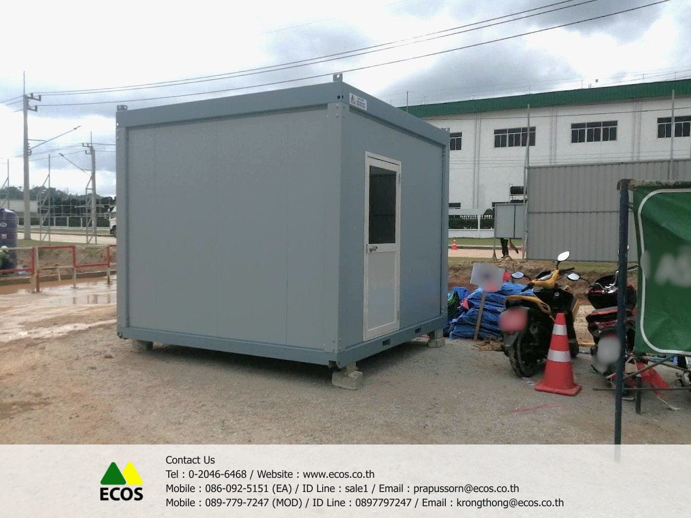 ตู้สำนักงานสำเร็จรูป W-House ขนาด 3x3 เมตร ผนังสีเทา มองจากมุมเฉียง เห็นประตูบานเปิดพร้อมช่องกระจกและเหล็กดัด วางบนหมอนรองที่หน้างานในนิคมอุตสาหกรรม